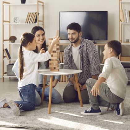 a family playing with stacked blocks in their new home