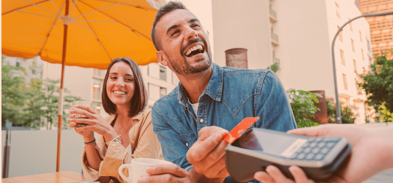 Smiling couple using a credit card to pay.