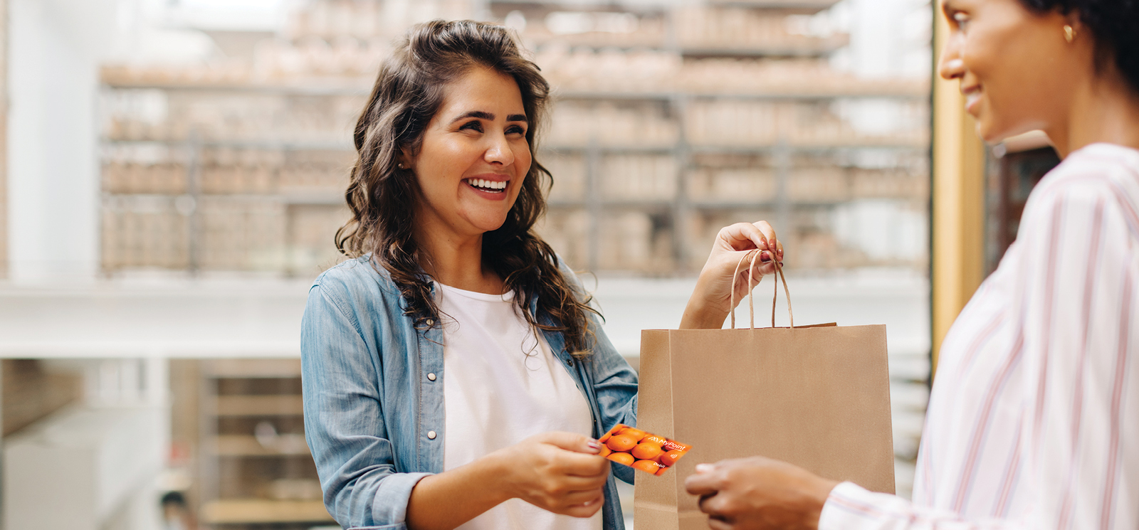 Smiling woman shopping with a debit card in her hand.